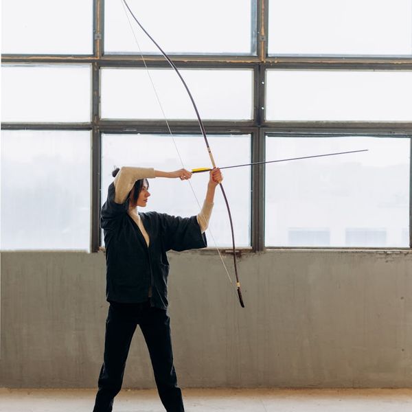 Person practicing a calming balance exercise by a large window with natural light.